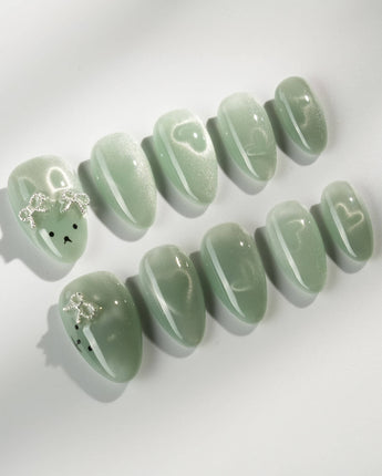 Thump Bunny_Mint press-on nails in extra short almond shape — Sage Green, Velvet Cat Eye Bow.