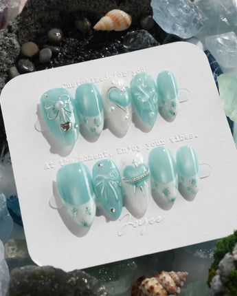 Exuma Blue pastel turquoise nails with sculpted bows, hearts, butterflies, and pearl accents