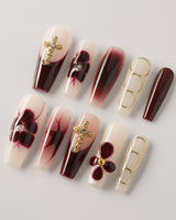 Tip Burgundy Nails in long coffin shape with deep red tips and ornate gold detailing