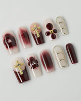 Tip Burgundy Nails in medium square shape with deep red tips and delicate gold accents