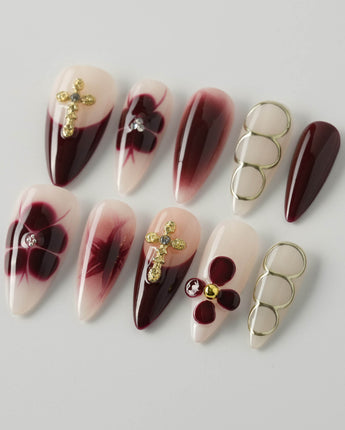Tip Burgundy Nails in medium stiletto shape with red tips, gold cross, and flower details