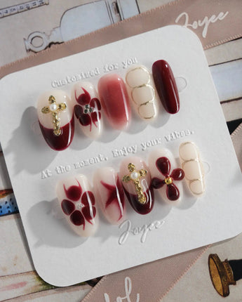 Tip Burgundy Nails in medium oval shape with burgundy French tips and gold floral accents