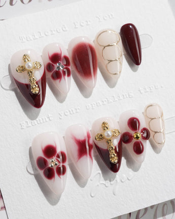Tip Burgundy Nails in short stiletto shape with burgundy tips, gold cross, and floral accents