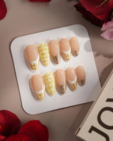 Tweed Light nails with nude base, gold shimmer French tips, and yellow tweed pattern