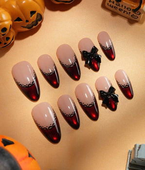 Vampire Lace press on nails with blood red French tips, hand-painted black lace trim and a 3D black bow on a nude base - image 2