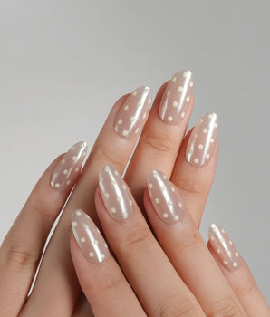 Lemon soda press-on nails with vanilla yellow tones, pearly nude shimmer and retro polka dots