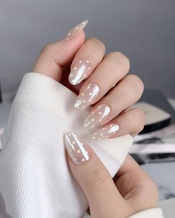 Lemon soda press-on nails with pearly aurora nude finish and creamy retro polka dot accents