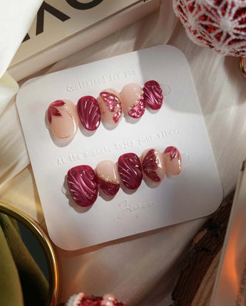 Velvet Flow press-on nails with glossy berry red gel and metallic butterfly wing linework
