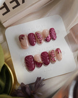 Velvet Flow short oval press-on nails with berry red cat-eye texture and butterfly wing art