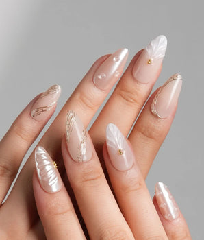 Venus medium almond press-on nails with pearl sheen, shell art, and gold accents