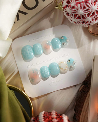 Winter wonderland press-on nails in extra short squoval shape — Icy Blue Snowflakes, Rhinestone Wreath & Hearts.