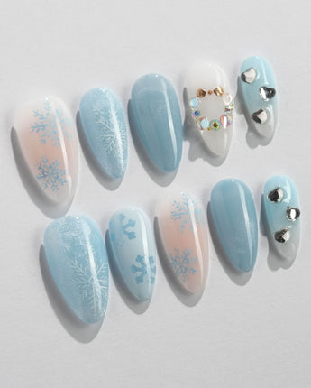 Winter wonderland press-on nails in medium almond shape — Icy Blue Snowflakes, Rhinestone Wreath & Hearts.
