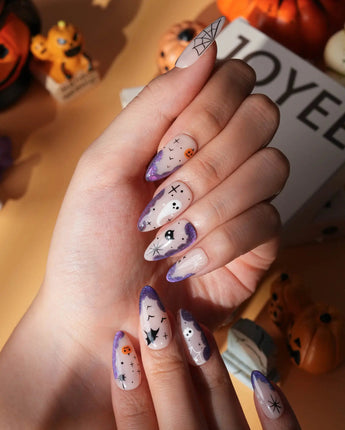 Witching Hour press on nails with a black spider web, bats, ghost, black cat and jack-o'-lanterns on a nude base with purple glitter edges - image 3
