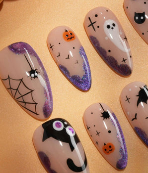 Witching Hour press on nails with a black spider web, bats, ghost, black cat and jack-o'-lanterns on a nude base with purple glitter edges - image 2