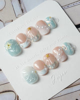 Yasawa Blue extra short squoval nails with 3D shells, pearls, and jelly blue glow