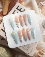 Yasawa Blue long stiletto nails with tropical jelly blue swirls, pearl strands, and starfish