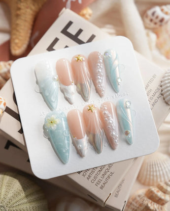 Yasawa Blue long stiletto nails with tropical jelly blue swirls, pearl strands, and starfish