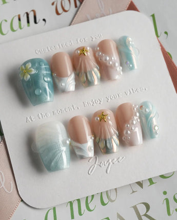 Yasawa Blue short coffin nails with shell-like swirls, pearl details, and blue shimmer