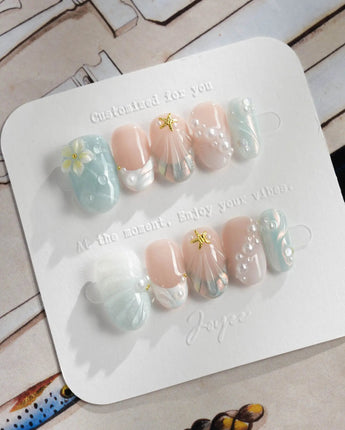 Yasawa Blue short oval nails with pearly ocean tones and gold starfish charm