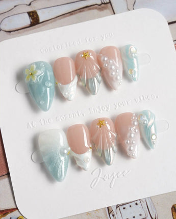 Yasawa Blue short stiletto nails with jelly blue swirls and 3D starfish details